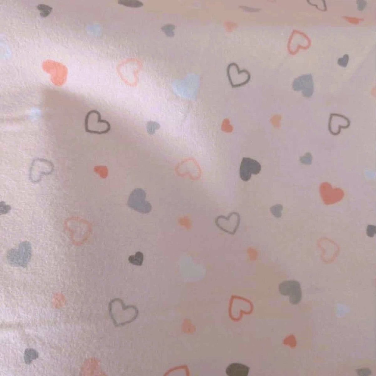 Pearl pink printed cotton flannel fabric with scattered pastel heart design by Robert Kaufman