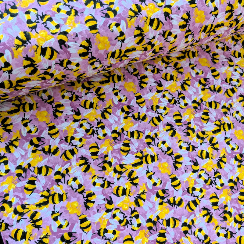 Cotton flannel fabric with yellow and black bees on a pink purple background, brushed for softness, Oeko-Tex certified, 44" wide.