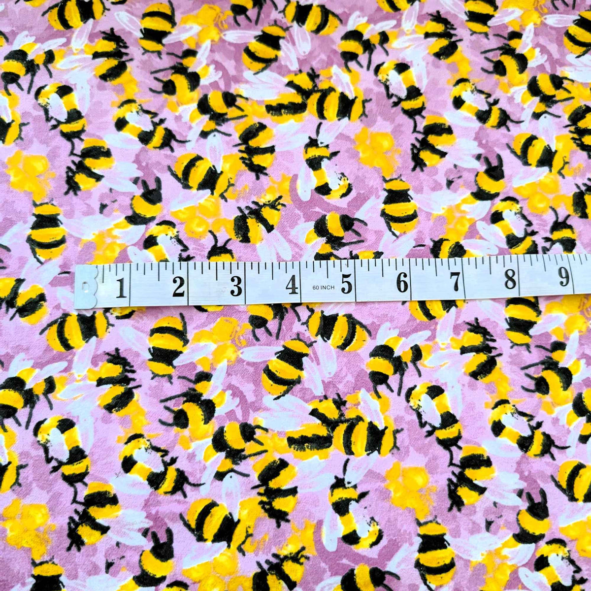 Cotton flannel fabric with yellow and black bees on a pink purple background, brushed for softness, Oeko-Tex certified, 44" wide.