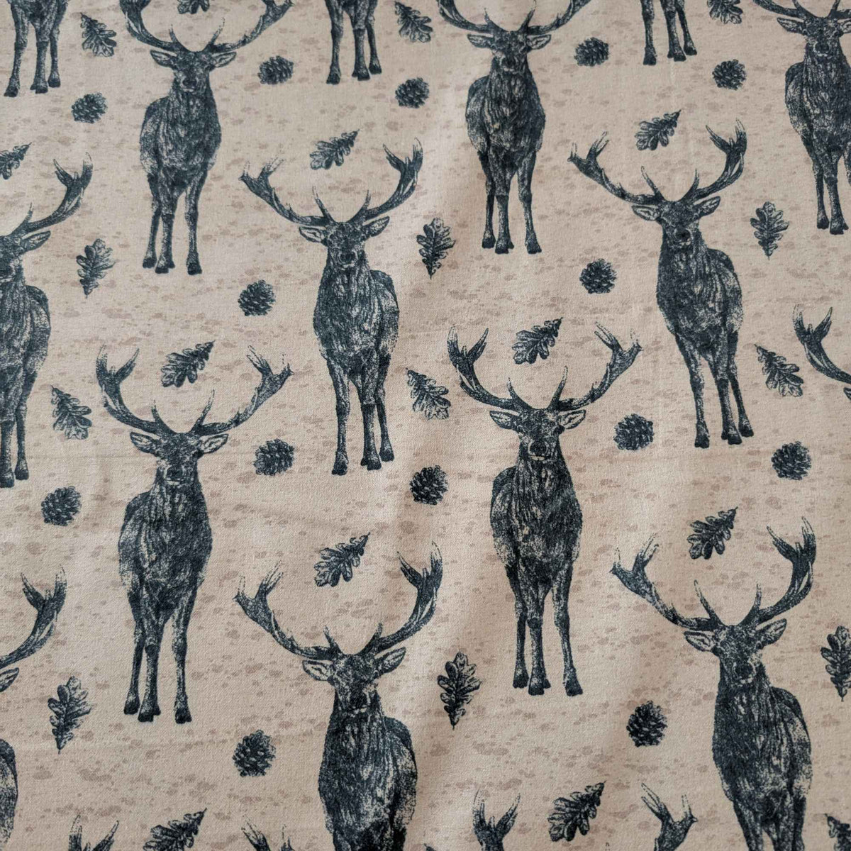 Cotton flannel fabric with stag deer, oak leaves, and pinecones on a rustic beige background, brushed for softness, Oeko-Tex certified.