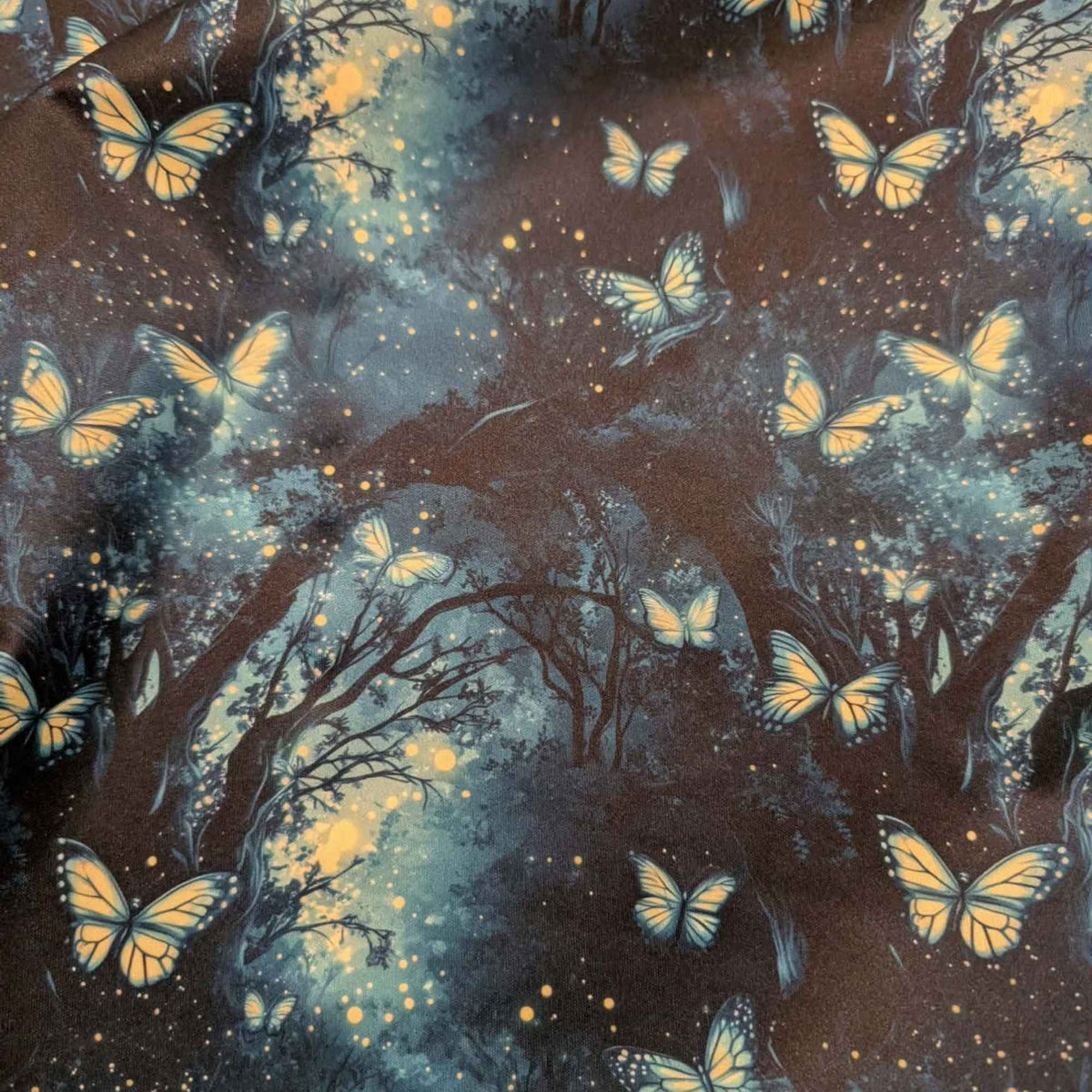Enchanted Butterfly Forest exclusive waterproof PUL fabric with glowing butterflies and fireflies among dark teal woodland trees