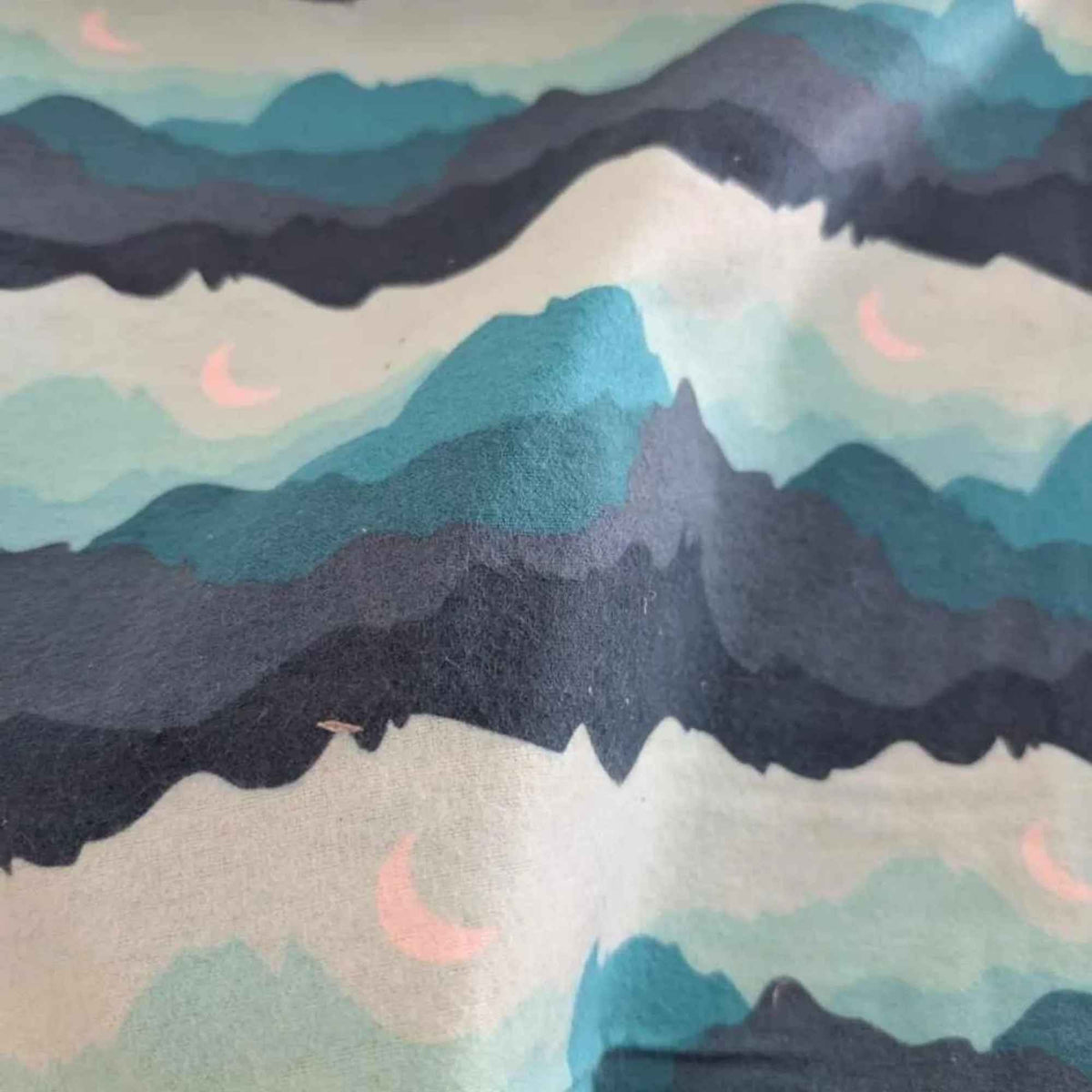 Teal, navy and grey mountain print flannel fabric with pink crescent moons