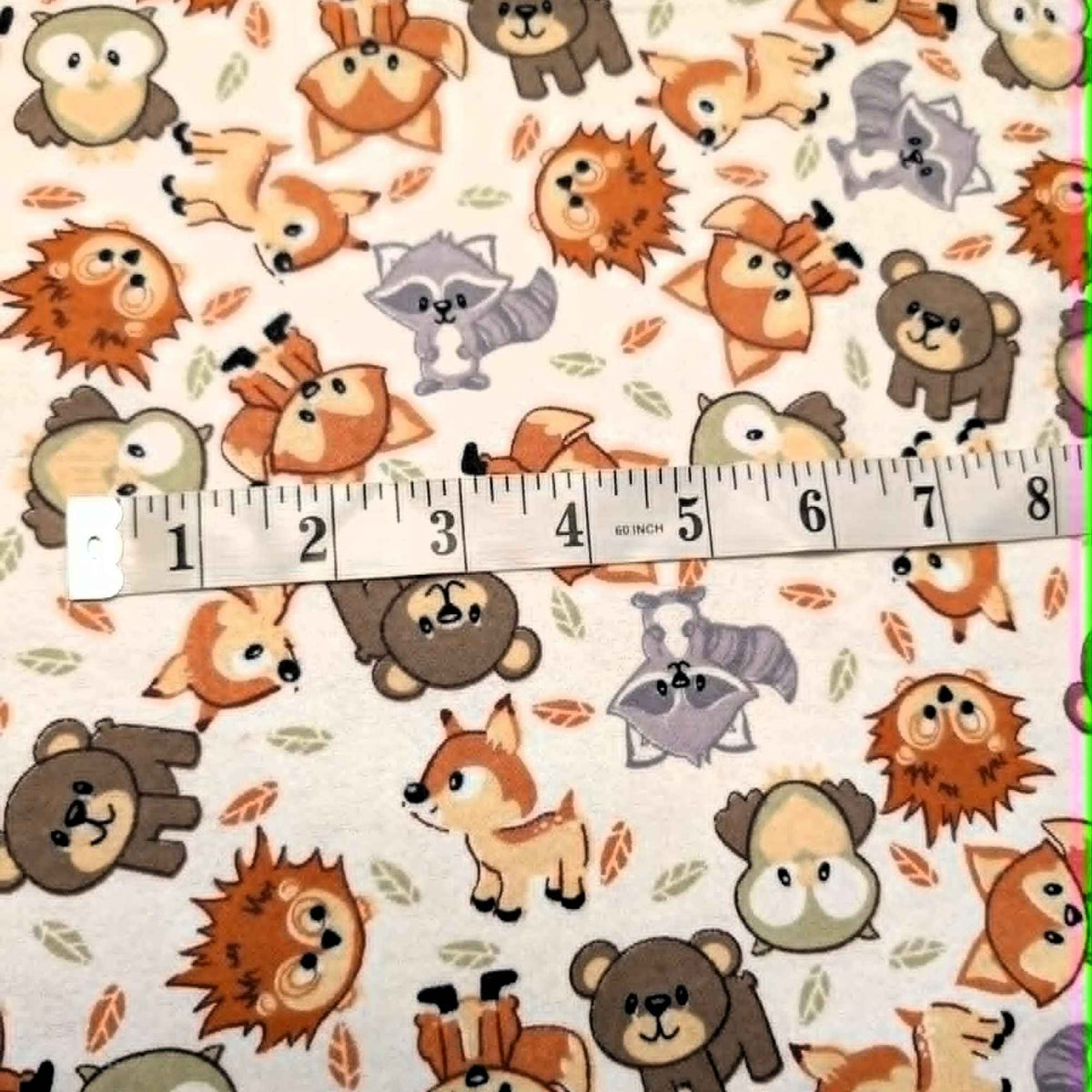 Double brushed flannel fabric featuring foxes, owls, bears, raccoons, deer, and hedgehogs on a cream woodland background.