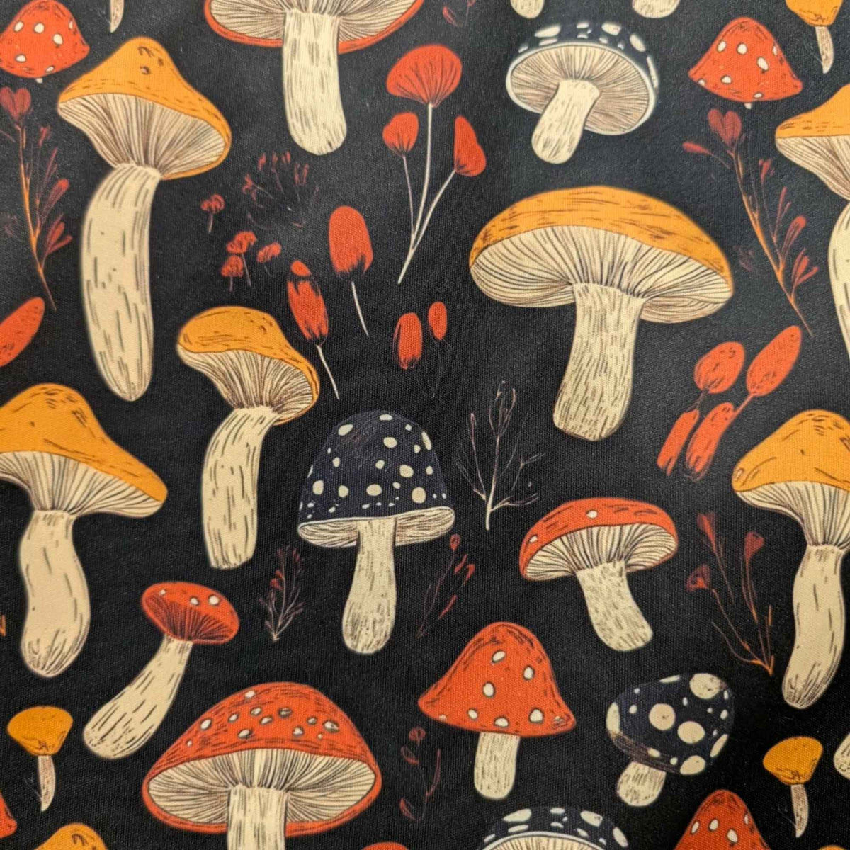 Red and golden mushroom print waterproof food safe PUL fabric on black background with botanical accents.