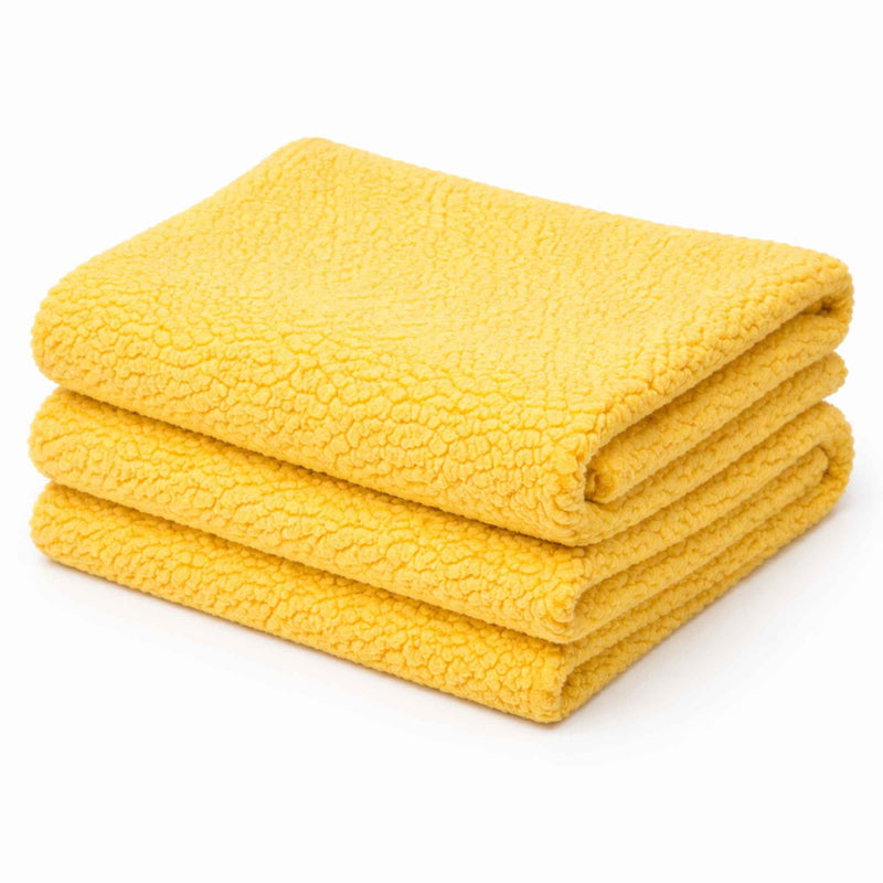 Bright yellow anti-pill polar fleece fabric close-up showing soft plush texture in a stack.