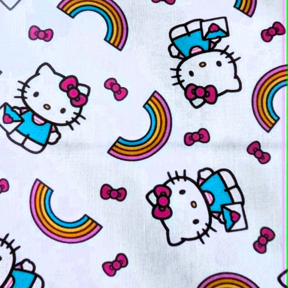 Officially licensed Hello Kitty rainbow cotton fabric by Springs Creative featuring Hello Kitty, colorful rainbows and pink bows on a white background.