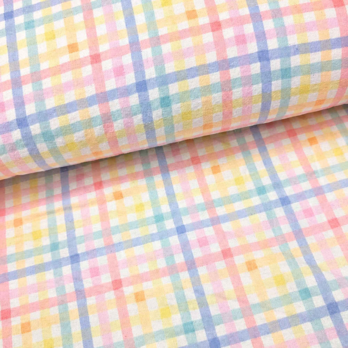 A close-up of a pastel plaid fabric with a soft watercolor effect, featuring intersecting lines of pink, yellow, blue, and green on a white background, with one corner rolled up.