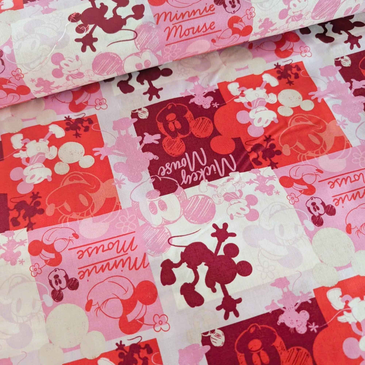 Mickey and Minnie Mouse collage cotton fabric in pink red and cream by Springs Creative CP80470
