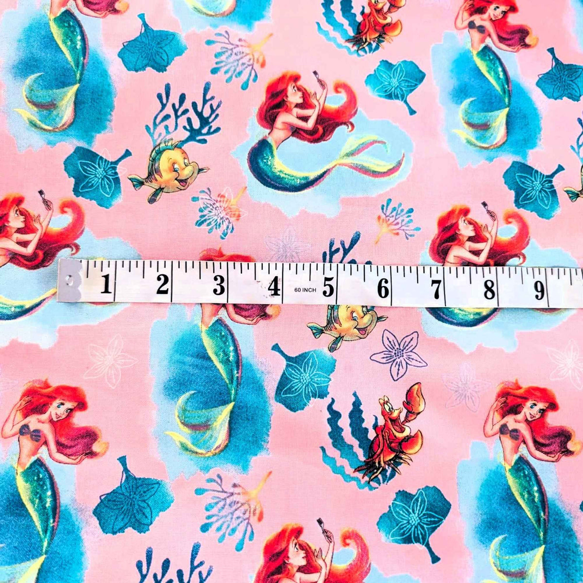 Disney Ariel Little Mermaid cotton fabric with Flounder and Sebastian on pink by Springs Creative CP80606
