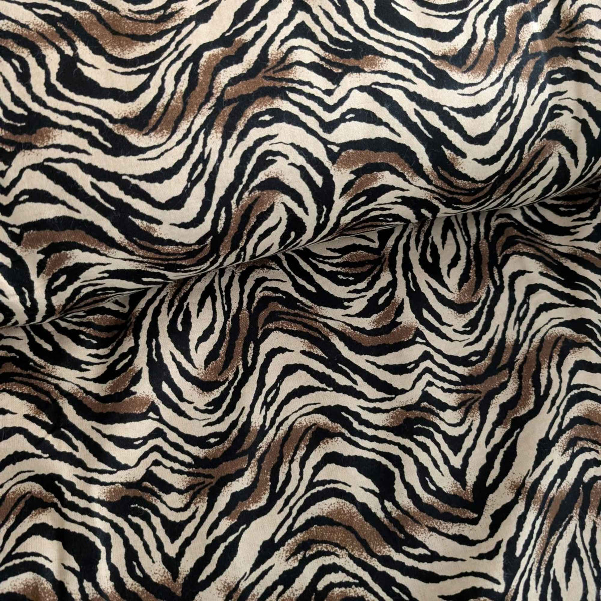 Tiger stripe cotton flannel fabric featuring wavy black stripes and brown accents on a cream background.