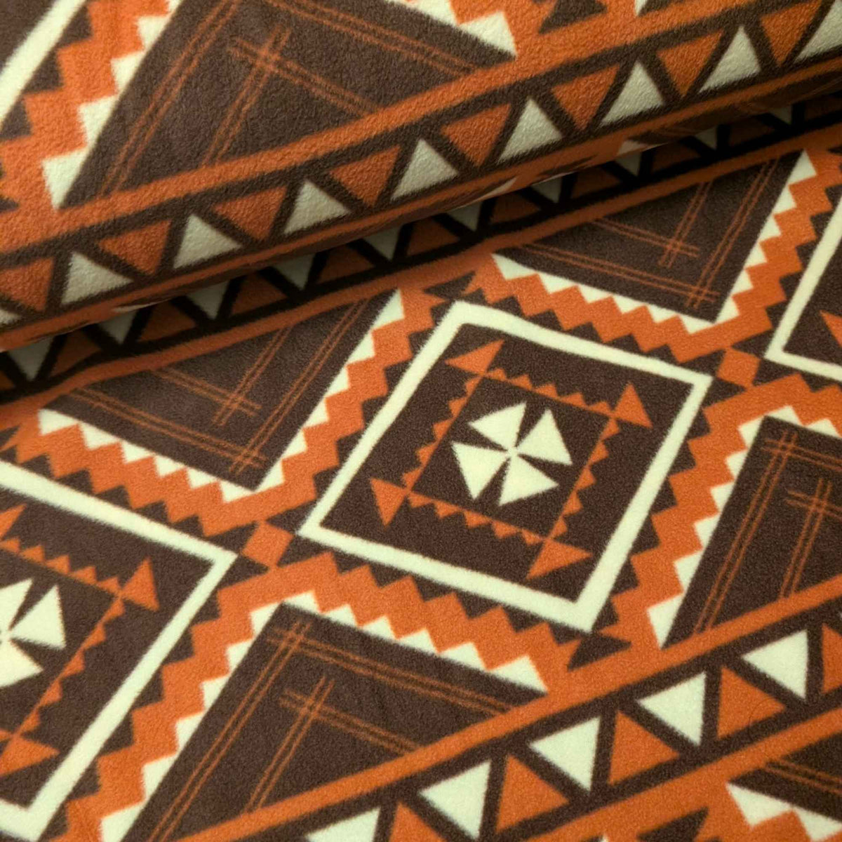 Cozy Cabin fleece fabric by Camelot with brown, rust and cream geometric diamonds, zigzags and triangle borders.