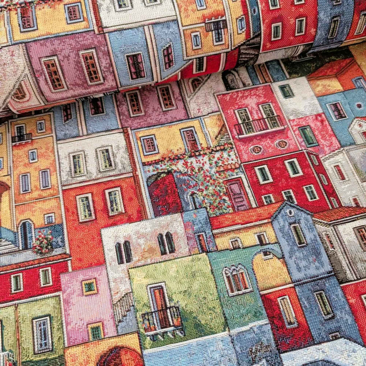 Mediterranean village Gobelin tapestry fabric featuring colourful houses, tiled roofs, balconies, arched doorways and winding stairways.