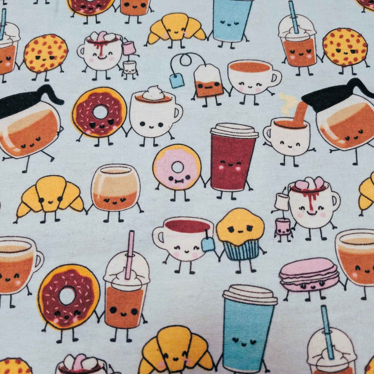A close-up of a mint green fabric featuring a repeating pattern of cute, hand-drawn cartoon food and drink characters with faces and small limbs, including donuts, croissants, coffee cups, iced drinks, and pastries.