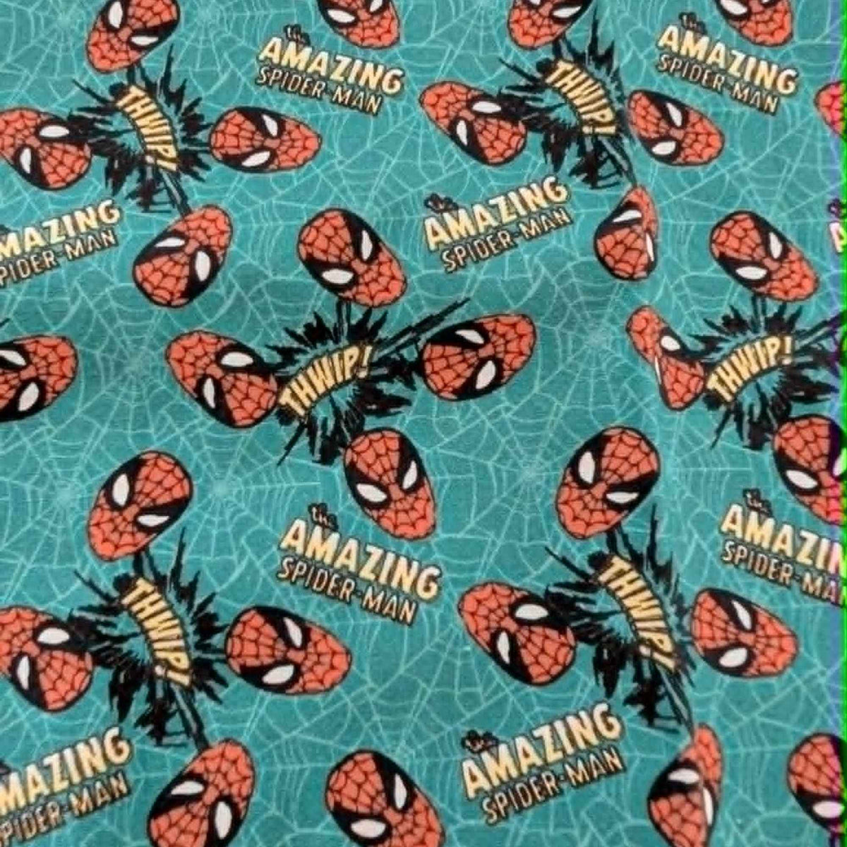 Marvel Amazing Spider-Man quilting cotton fabric by Camelot Fabrics featuring Spider-Man masks, Amazing Spider-Man logos, and comic-style Whip graphics on a turquoise web-pattern background.