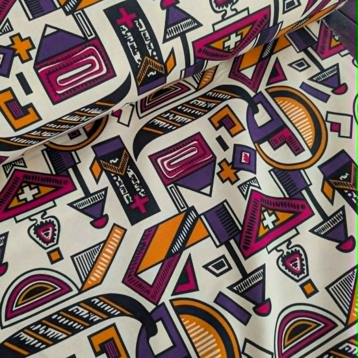 African-inspired geometric tribal double brushed flannel fabric featuring colorful abstract geometric symbols on a cream background.