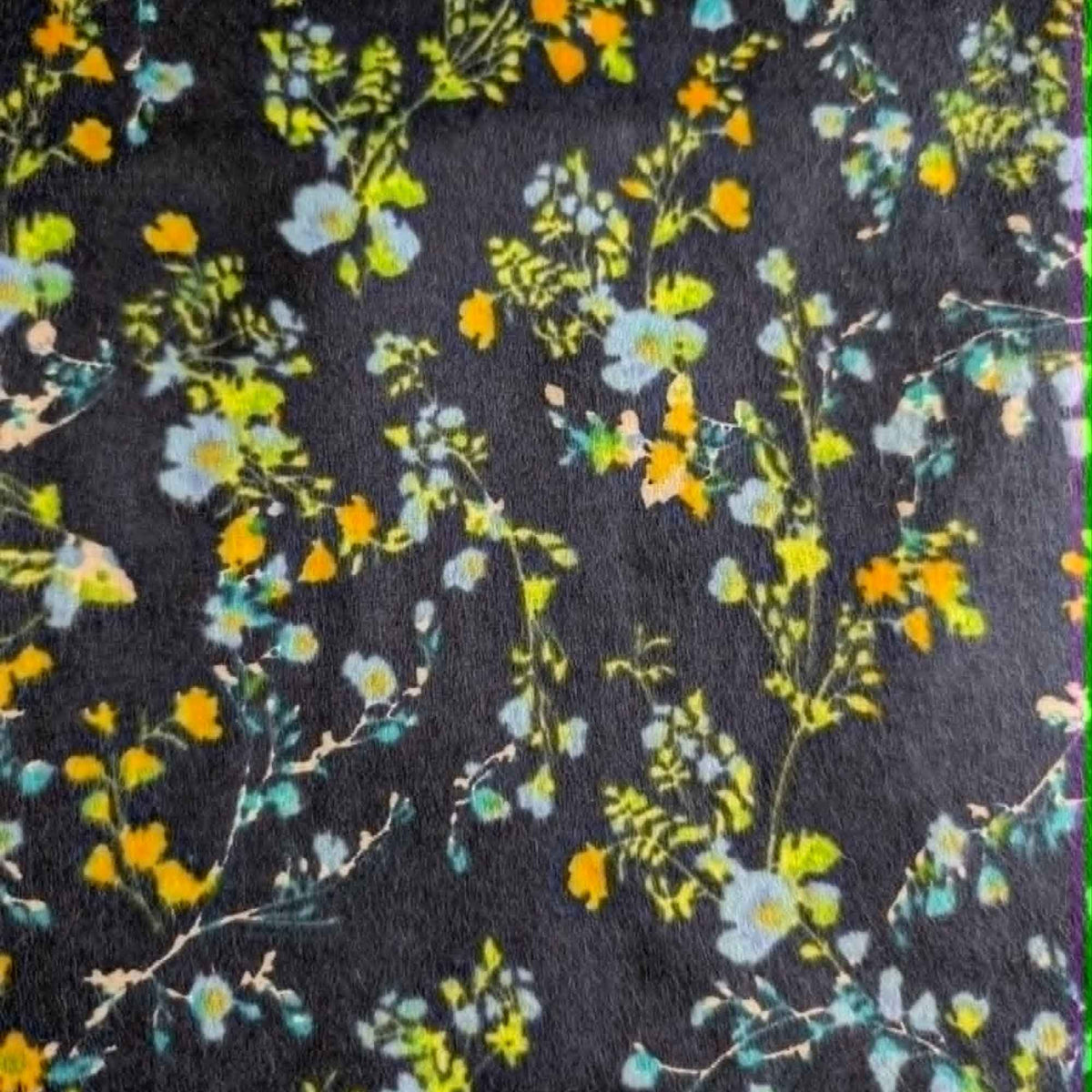 Double brushed flannel fabric featuring delicate yellow, blue, and green wildflowers with trailing vines on a navy background.