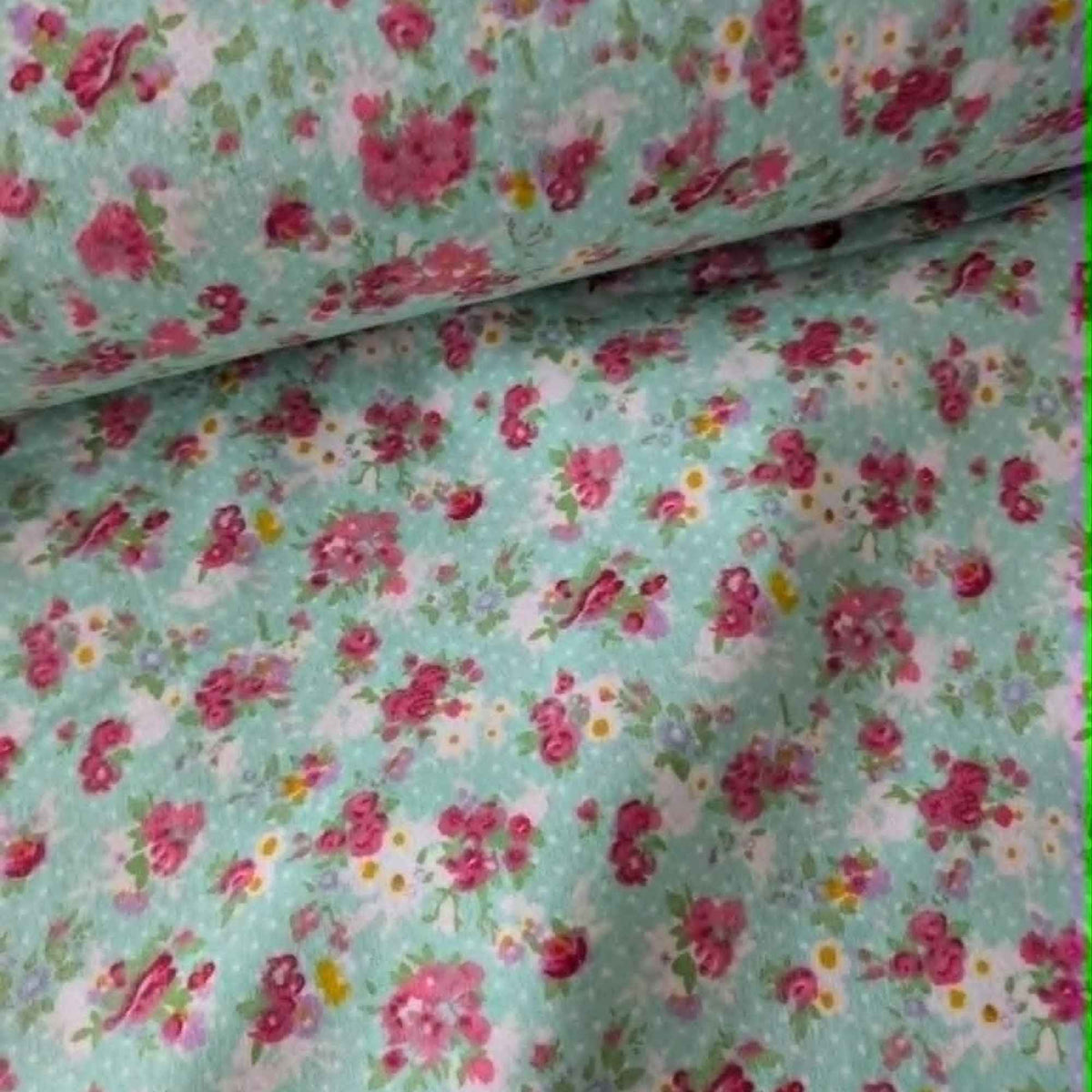 Double brushed flannel fabric featuring pink rose bouquets, delicate wildflowers, and floral sprigs on a soft mint green background.
