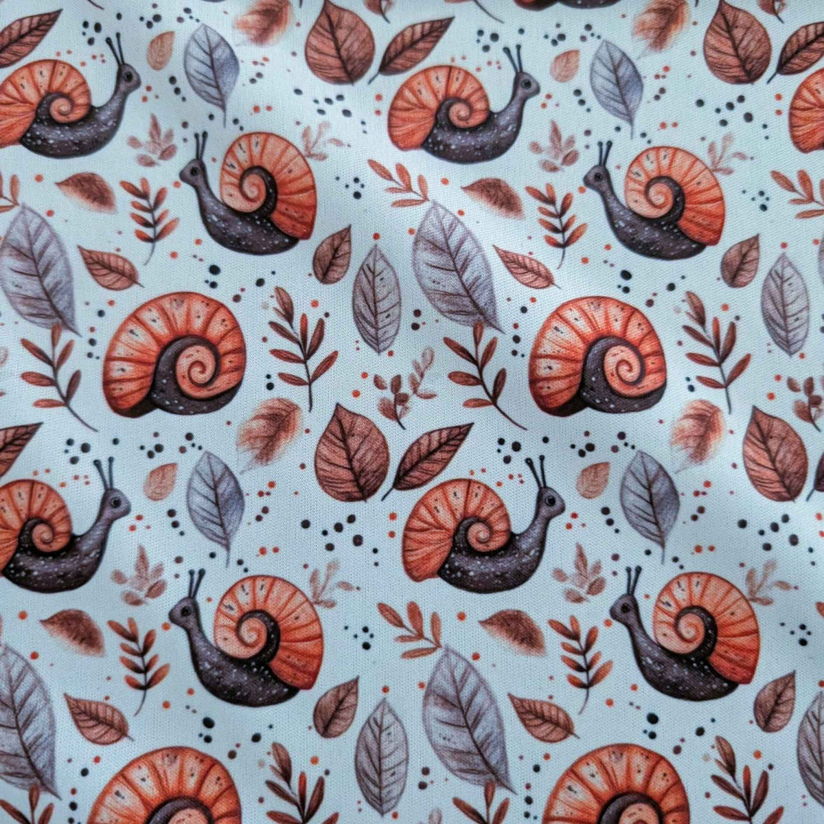 Woodland Snails and Autumn Leaves exclusive waterproof PUL fabric with orange-shelled snails and brown leaves on cream