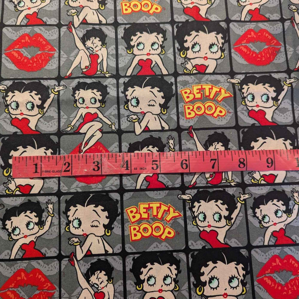 Betty Boop poses in 2" frames on grey fabric