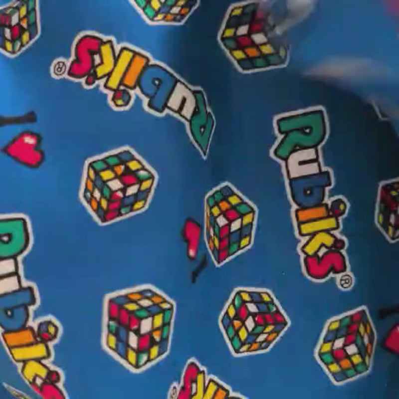Video of Blue cotton flannel fabric featuring colorful Rubik’s Cubes and “I ♥ Rubik’s” logos, officially licensed by Camelot Fabrics