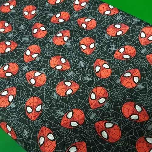 Camelot Fabrics 13080018 Marvel Spiderman fabric with red Spiderman faces tossed on a black background with spider web details.